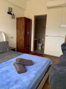 a bedroom with a bed with two towels on it at Batu Feringgi Sri Sayang Apartment in Batu Ferringhi