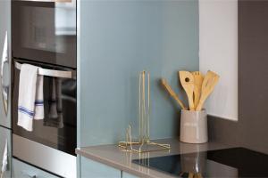 a kitchen with a counter with wooden utensils at City Chic: Elegant Flat in a Prime Location in London