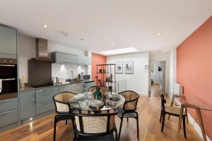a kitchen and dining room with a table and chairs at City Chic: Elegant Flat in a Prime Location in London