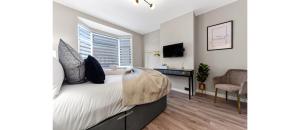 a bedroom with a bed and a desk and a chair at Stylish 3BR Home with Garden Sleeps 6 in London +23 photos