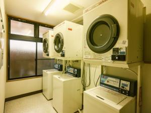 a laundry room with washing machines and a window at 古民家ホテル 結 YUWAI in Hakuba