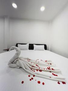 a white bed with red rose petals on it at Villa De Jeff in Puducherry