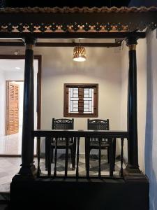 tavolo da pranzo con 2 sedie e lampadario pendente di Villa De Jeff a Pondicherry
