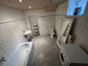 a bathroom with a tub and a toilet and a sink at Gästezimmer Euratsfeld in Euratsfeld