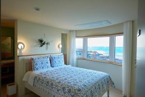 sypialnia z łóżkiem i widokiem na ocean w obiekcie Hay Day Jeju w mieście Czedżu