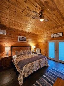 a bedroom with a bed and a wooden ceiling at 5 Min To Beaver Lake, King Bed, Fire Pit, Jetted Tub #3 in Eureka Springs