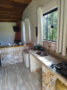 a kitchen with a sink and a counter top at Chalé Sonho Diniz 1 in Monte Verde