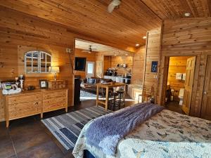 a bedroom with a bed and a kitchen in a cabin at Honey Bear Haven Suite 3 in Eureka Springs