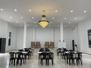DGeting Beach Resort في تومبات: غرفة كبيرة فيها طاولات وكراسي وثريا