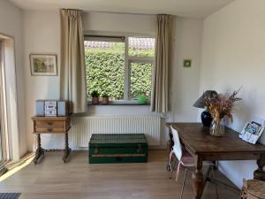 ein Wohnzimmer mit einem Tisch und einem Fenster in der Unterkunft huize Louwra in Egmond-Binnen