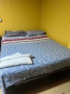 een bed met blauwe lakens en kussens in een kamer bij Hostal La Mansion in Antofagasta