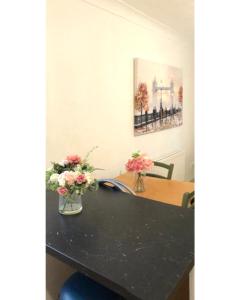 a table with two vases of flowers on it at 2 Bed Flat Privite in Canada Water in London