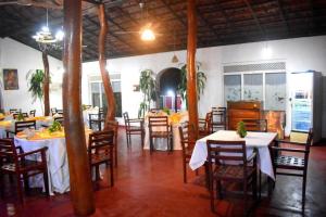 un comedor con mesas y sillas en un restaurante en Habarana INN, en Habarana