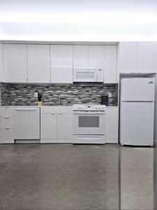 a kitchen with white appliances and white cabinets at Tremont Smart 10 - A KCM Property in Cleveland