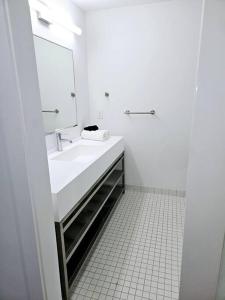 a white bathroom with a sink and a mirror at Tremont Smart 10 - A KCM Property in Cleveland