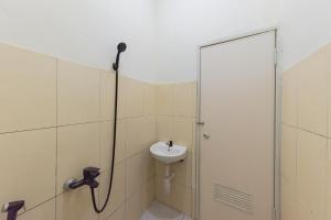 La salle de bains est pourvue d'un lavabo et d'une douche. dans l'établissement RedDoorz Syariah @ Jl Raya Sukabumi, à Sukaraja