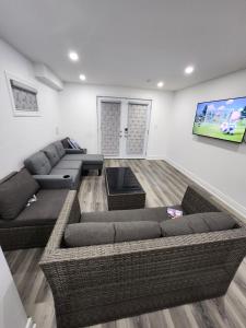 een woonkamer met 2 banken en een flatscreen-tv bij New Modern cozy room in Innisfil in Innisfil