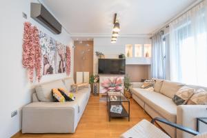- un salon avec un canapé et une télévision dans l'établissement The Luxury Loft by Cloudkeys, à Athènes