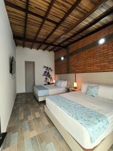 - une chambre avec 2 lits et un mur en briques dans l'établissement La Colina Balance Hotel, à Chinácota