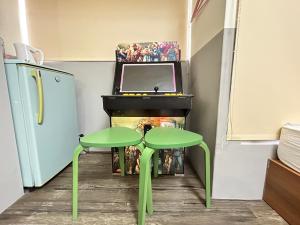 a room with two green tables and a tv at 逢甲 Toy RooM in Taichung