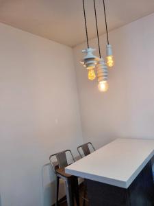 a dining room table with chairs and lights at Food House in Andong