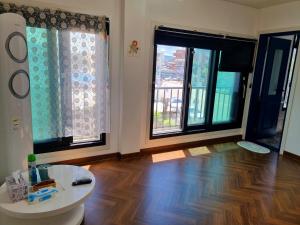ein Wohnzimmer mit Holzboden und Fenstern in der Unterkunft Food House in Andong