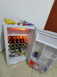 een open koelkast gevuld met veel drankjes bij HOSTAL GRAND IBIZA in Huacho