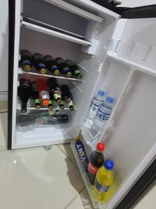 un réfrigérateur ouvert rempli de nombreuses boissons et de bouteilles. dans l'établissement HOSTAL GRAND IBIZA, à Huacho