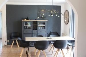 a dining room with a white table and black chairs at Ferienhaus an der Grenze zu Hamburg Zentrale Lage in Neu Wulmstorf