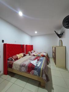 una camera con letto con testiera rossa di HOSTAL GRAND IBIZA a Huacho