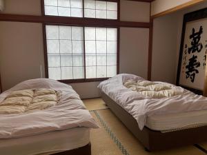 熱海的住宿－Marina Bay Atami，带2扇窗户的客房内的2张床