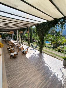 um pátio exterior com mesas, cadeiras e vinhas em La Colina Balance Hotel em Chinácota