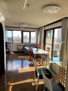 a dining room with a table and chairs and windows at Marina Bay Atami in Atami