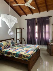 um quarto com uma cama e uma ventoinha de tecto em ShaNicky Villa em Kandana