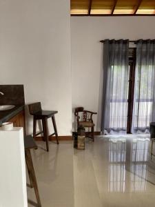 uma sala de estar com uma mesa e cadeiras e uma janela em ShaNicky Villa em Kandana