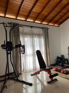 a room with a gym with a treadmill and a chair at ShaNicky Villa in Kandana