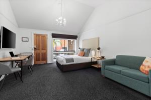 Habitación de hotel con cama y sofá en All Seasons Resort Hotel Bendigo, en Bendigo
