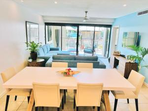 a dining room and living room with a table and chairs at Lagoon Swimout Absolute Pool Front - Slice of Paradise - Sea Temple Pt Douglas in Port Douglas