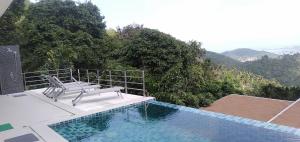 a bench sitting next to a swimming pool at Great Sea View Mountain Villa Koh samui in Amphoe Koh Samui