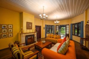 a living room with orange furniture and a fireplace at Ferncliff Bungalow in Nuwara Eliya