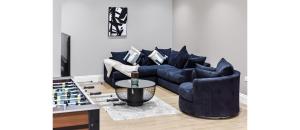 a living room with a blue couch and a table at Serene Escape: Stylish & Cozy 2BR Flat in London