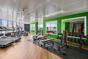 un gimnasio con una pared verde y máquinas de correr en Hidden Gem Studio - Affordable en Dubái