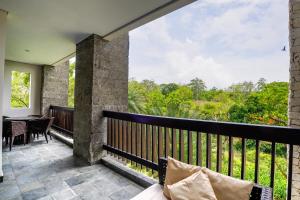 a balcony with a view of the forest at Royal Tulip Springhill Resort Jimbaran in Jimbaran