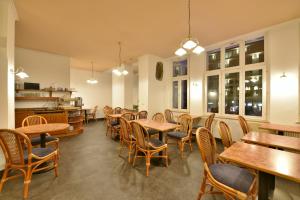 a restaurant with wooden tables and chairs and windows at Hotel Meereseck in Bansin