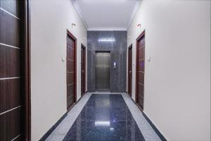 a corridor of a building with a tile floor and doors at FabExpress D Grand in Hyderabad