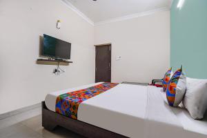 a bedroom with a large bed and a flat screen tv at FabExpress D Grand in Hyderabad