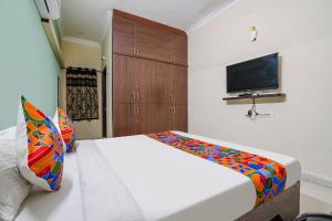 a bedroom with a bed and a tv on the wall at FabExpress D Grand in Hyderabad