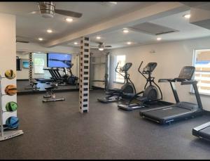 a gym with several exercise bikes and a flat screen tv at Heart of Houston NRG/TMC Beautiful Studio 77030 in Houston