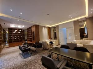 a hotel lobby with couches and a table and chairs at Gin Residence in Jakarta