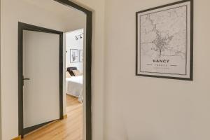 korytarz z lustrem i oprawionym obrazem na ścianie w obiekcie Suites indépendantes toutes équipées Leopold ou Carnot w Nancy